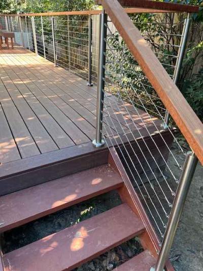 A backyard deck, secured with stainless posts & wire balustrade